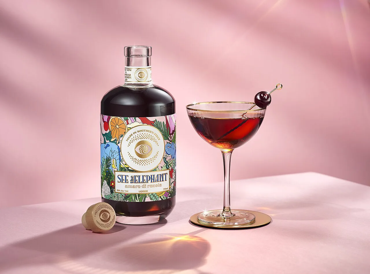 An amaro cocktail beside the bottle.