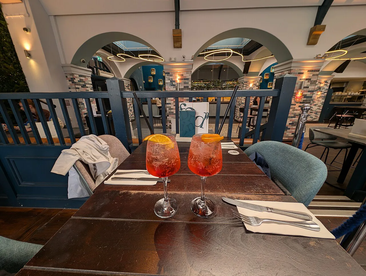 Two spritz cocktails on a restaurant table.