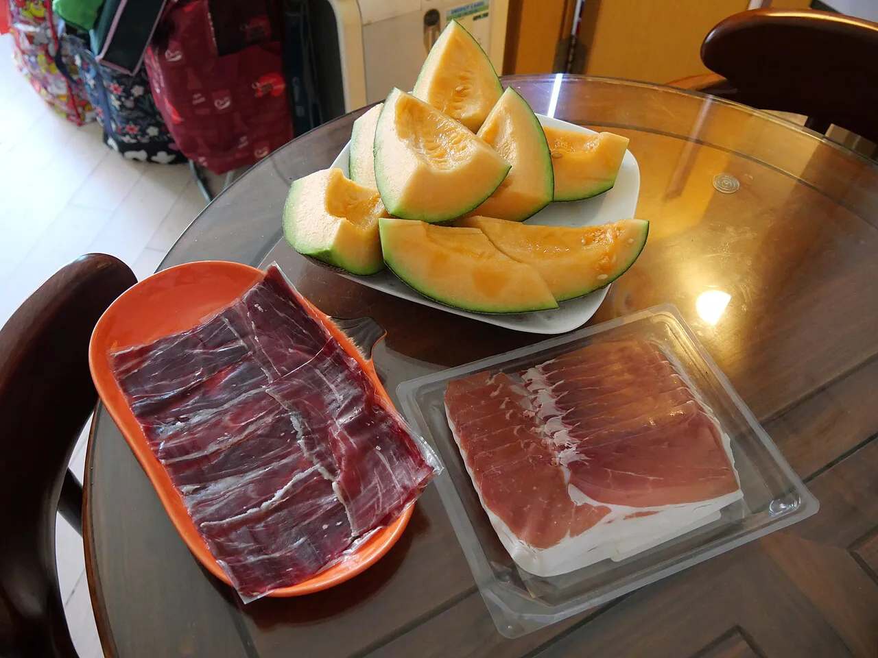 Melon with cured ham on a table in Parma.