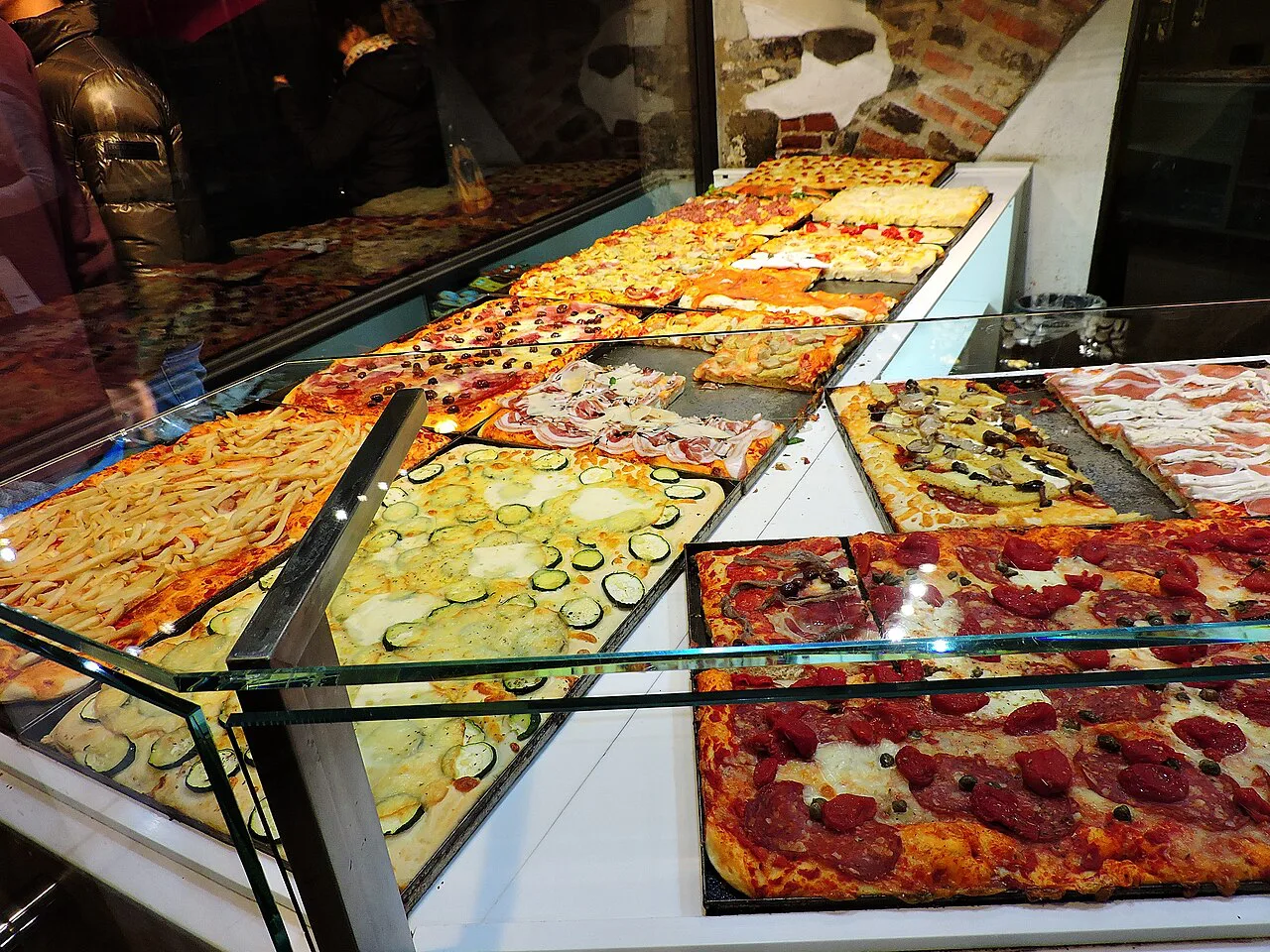 Pizza slices in a bakery window in Bergamo.