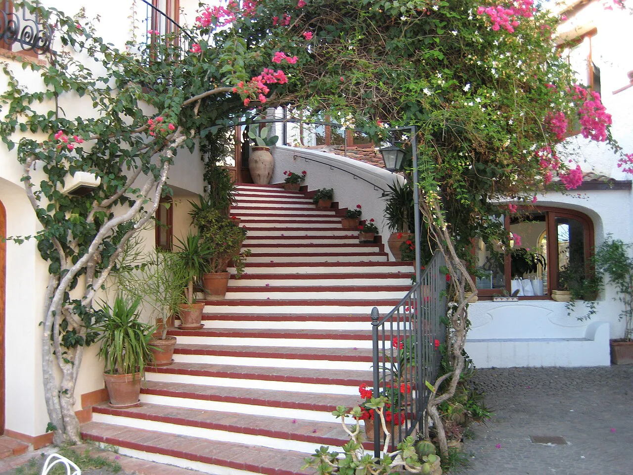 Flower-lined stairs to a restaurant in Cefalù.