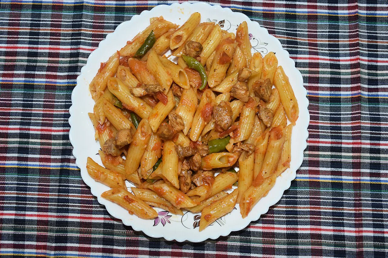 A plate of penne in red sauce.