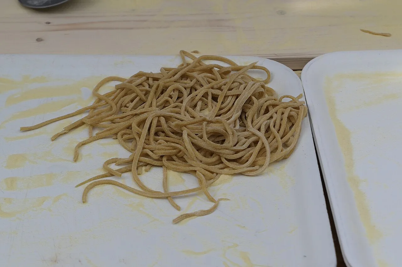 Fresh pasta strands on a tray.