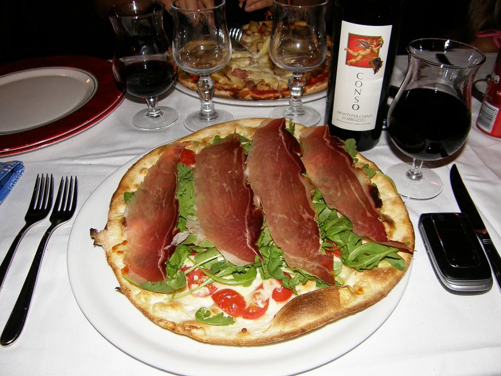 Pizza with cured ham and rocket.
