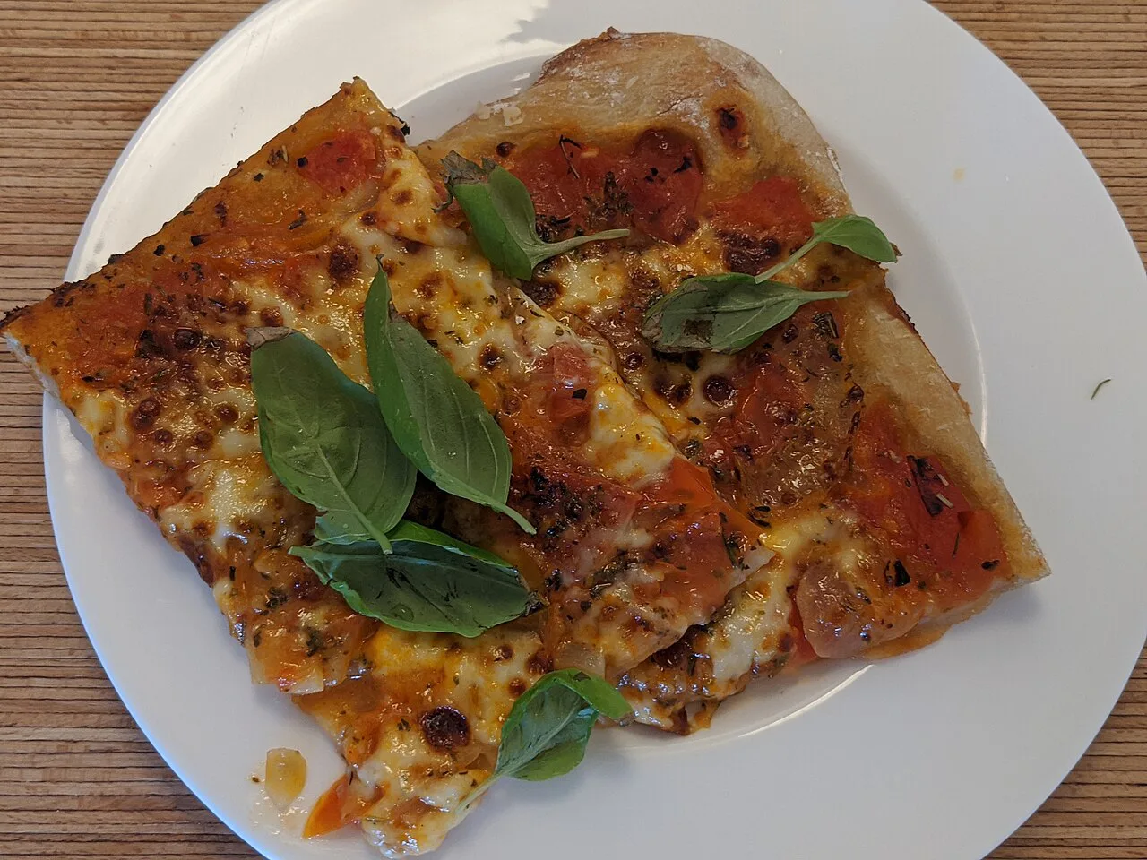Margherita pizza slices topped with basil.