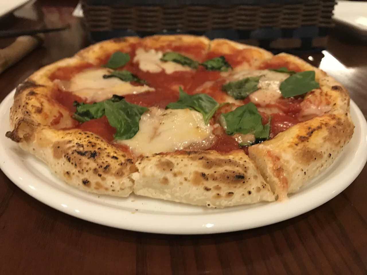 A margherita pizza on a plate.