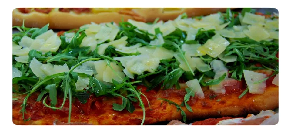 Pizza with rocket and Parmesan shavings in Syracuse.