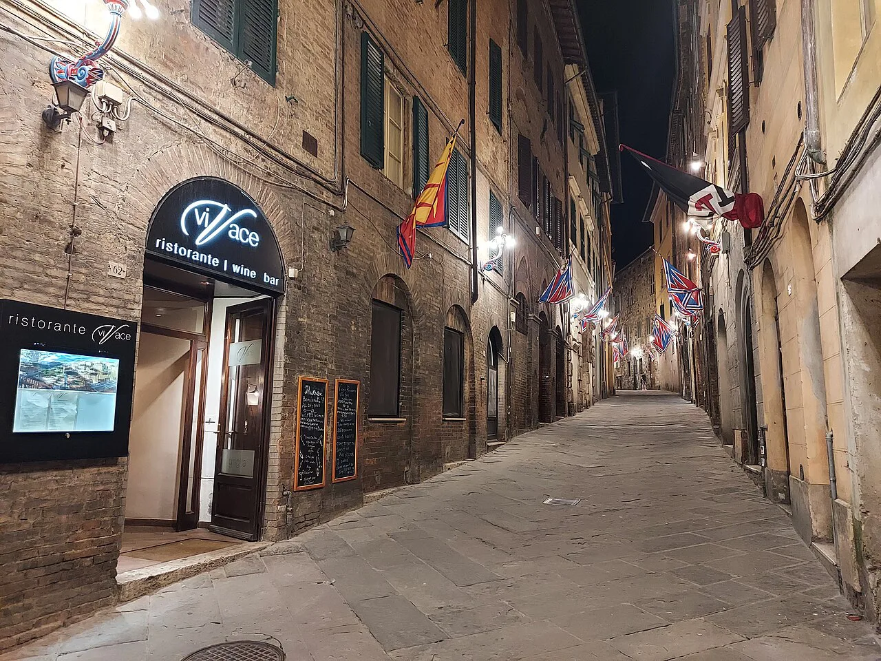 Old-town street with a restaurant in Siena.