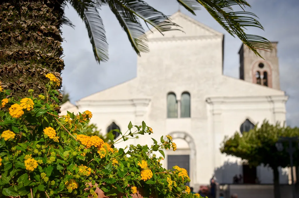 Ravello Cathedral framed by flowers and palms.