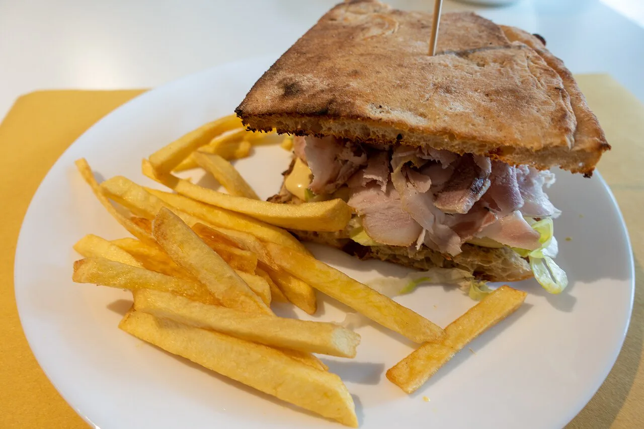 Sandwich and chips on a café table in Genoa.