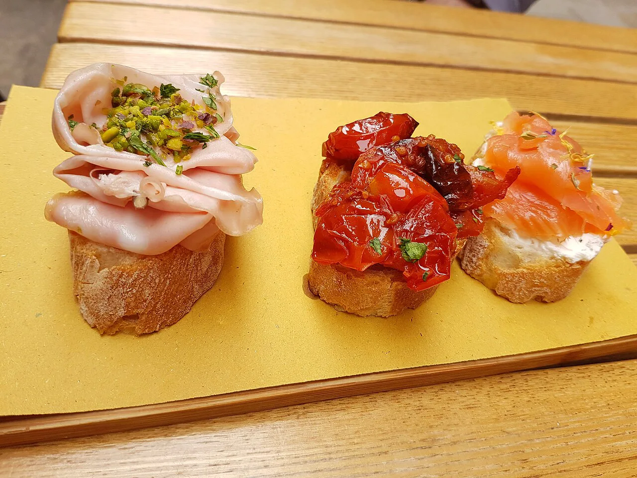 Cicchetti topped with ham, tomatoes and salmon.
