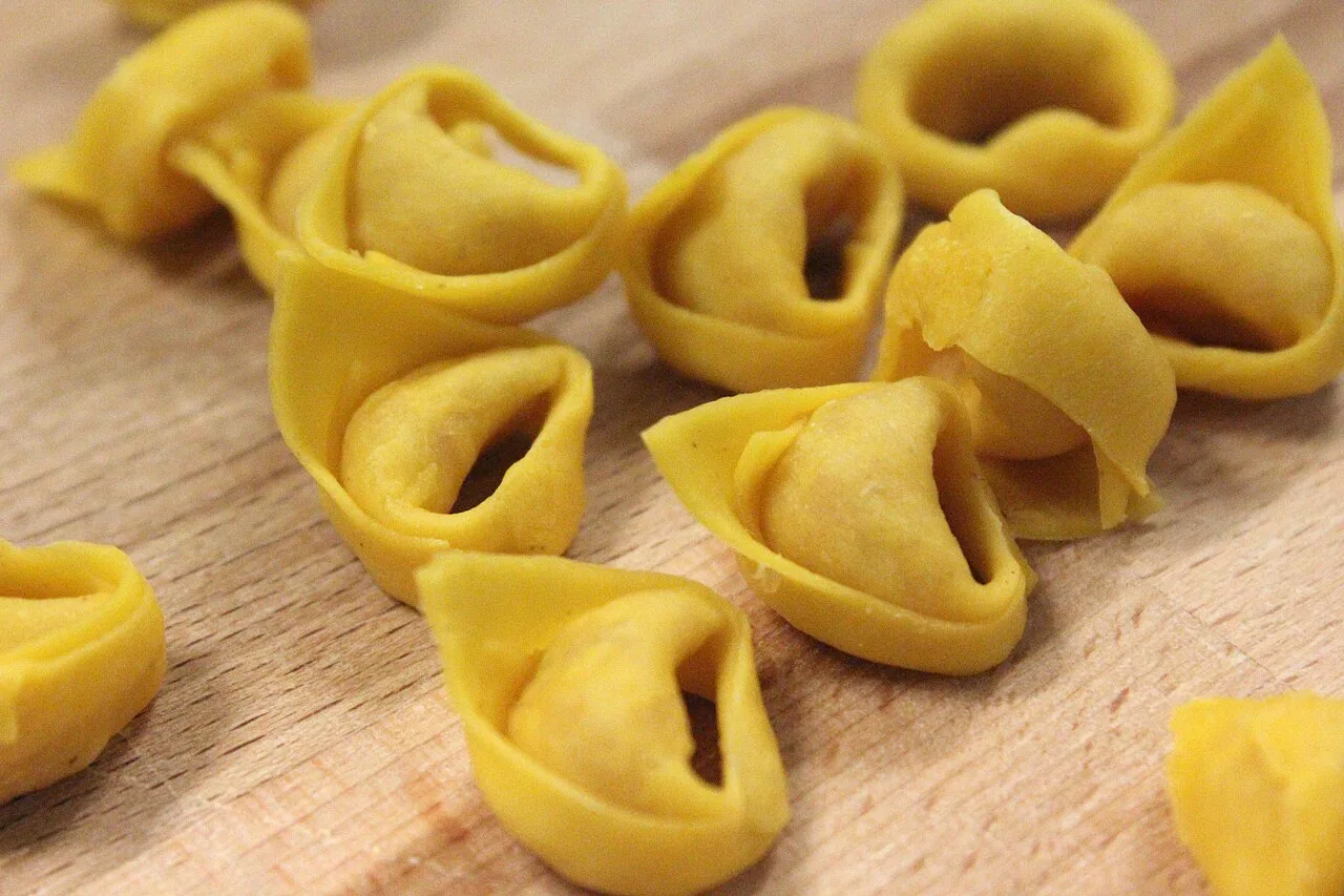 Fresh tortellini on a wooden board.