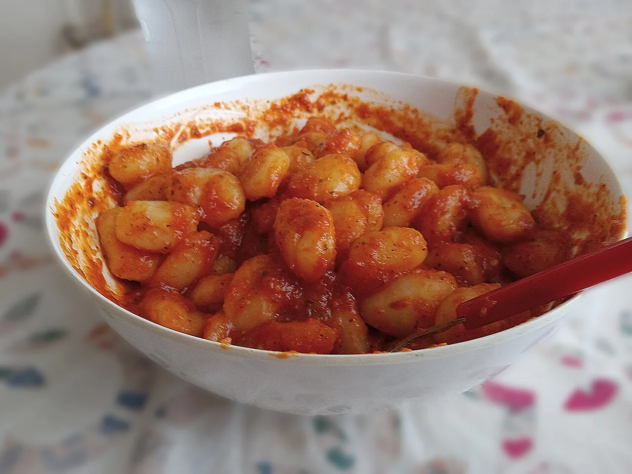 A bowl of gnocchi in tomato sauce.