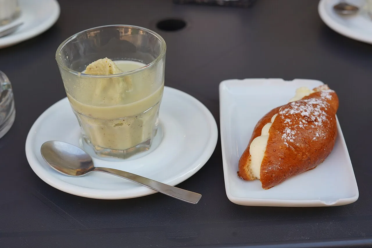 A glass of granita with a sweet brioche.