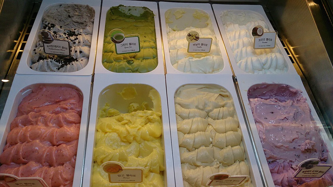 Trays of artisan gelato behind glass.