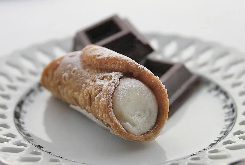 A cannolo siciliano with chocolate squares.