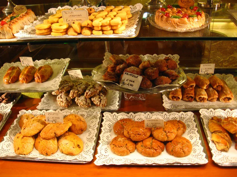 Pastries on trays in an Italian shop window.