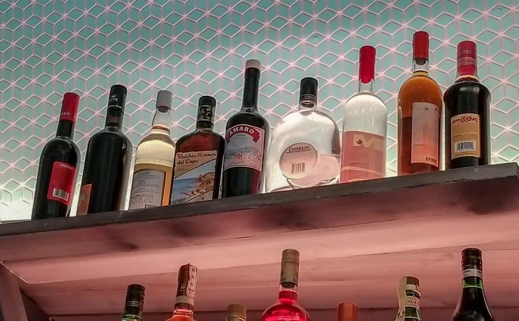 Shelf of amaro bottles.
