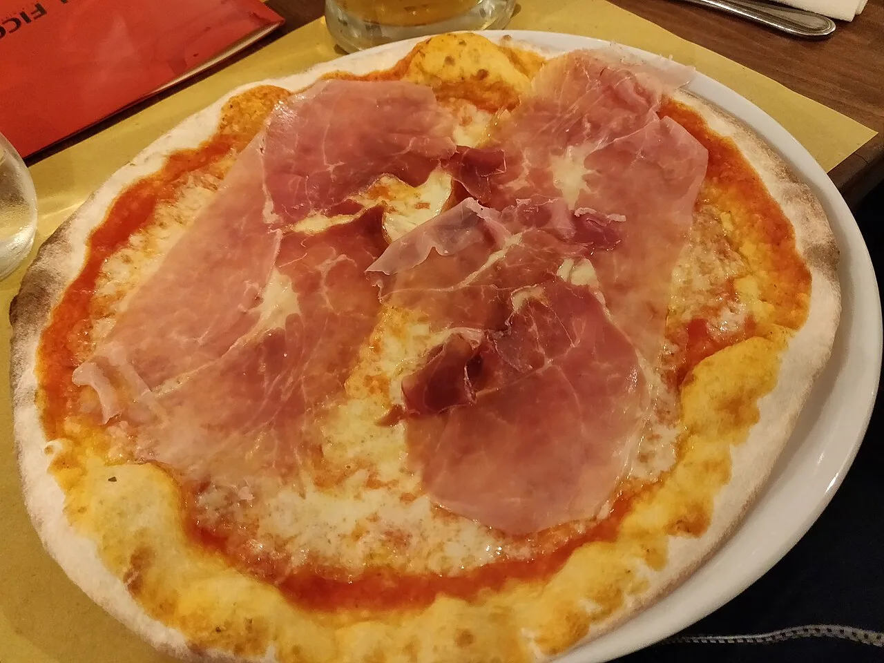 A pizza topped with prosciutto.