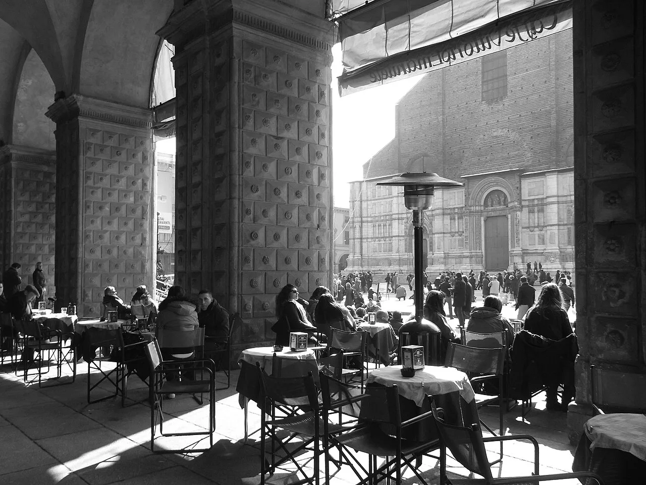 Café tables under the arcades in Bologna.