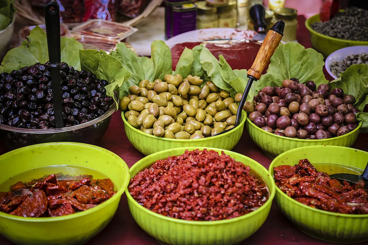Olives and sun-dried tomatoes at a market stall in Ortigia.