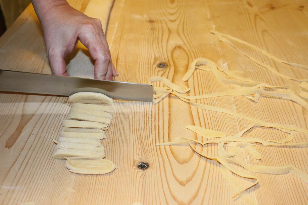 Cutting fresh egg pasta with a knife.
