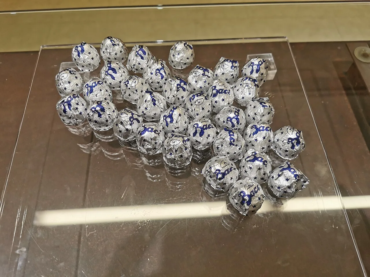 Foil-wrapped chocolates on a glass counter.