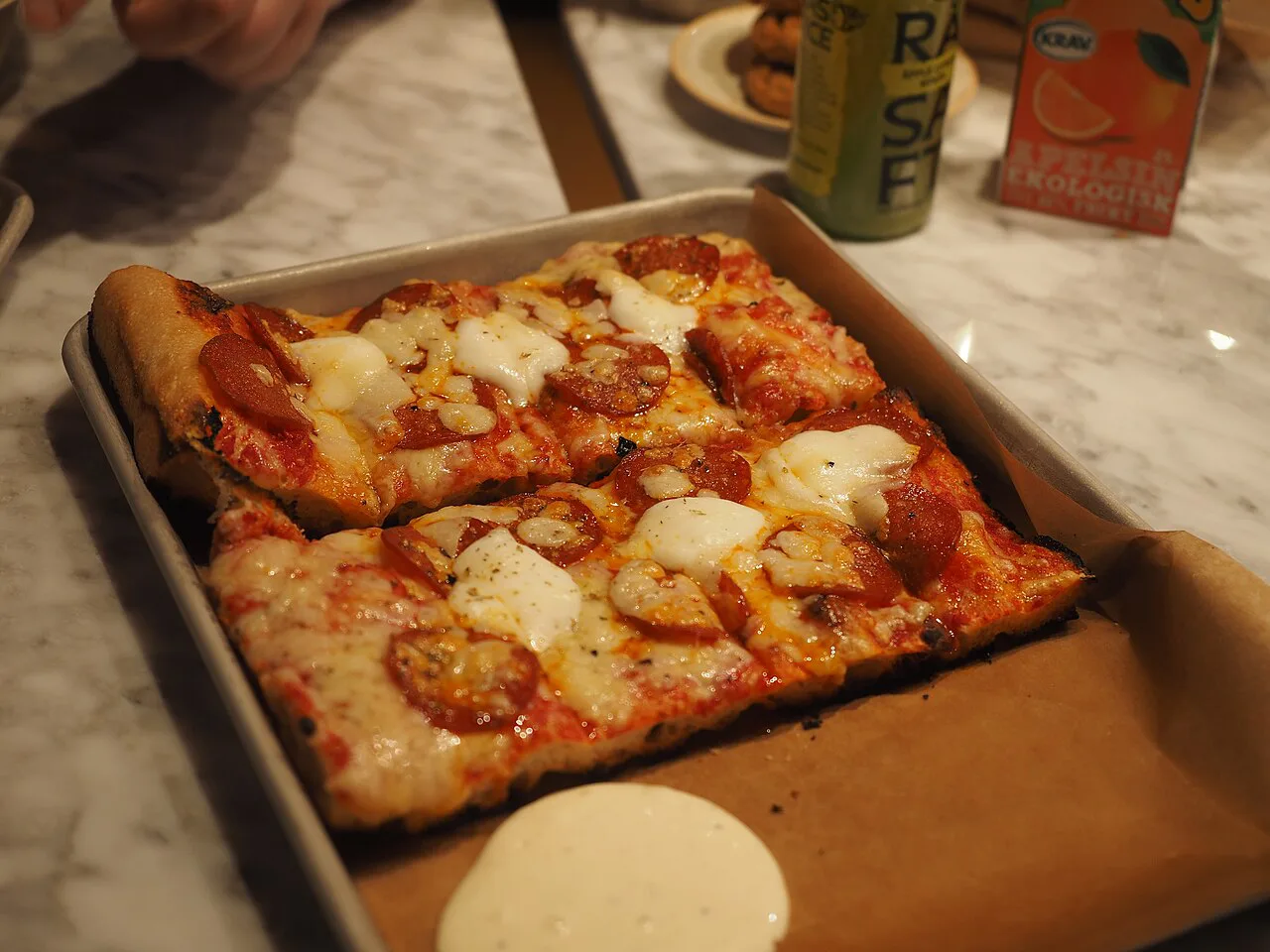 Pizza al taglio slices on a tray.