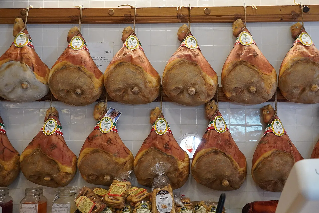 Prosciutto di Parma hams hanging in a curing room.