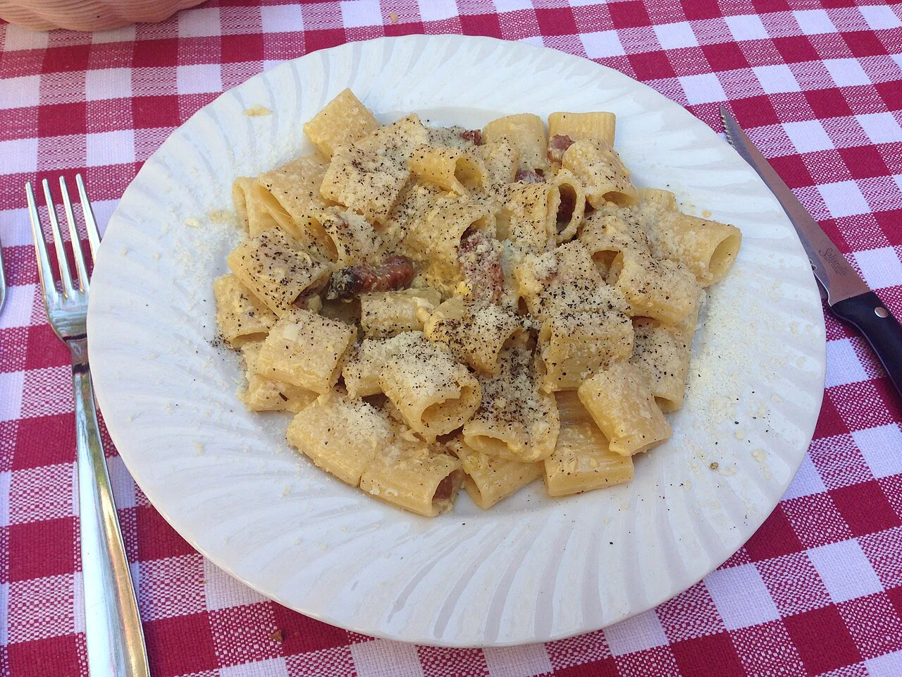A plate of pasta with pepper and cheese in Ostia Antica.