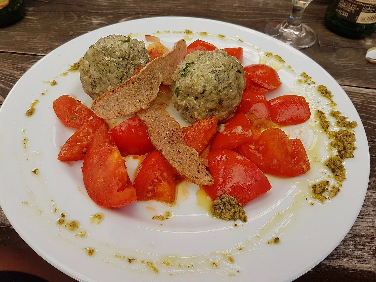 Herb dumplings on tomatoes, a South Tyrolean dish.