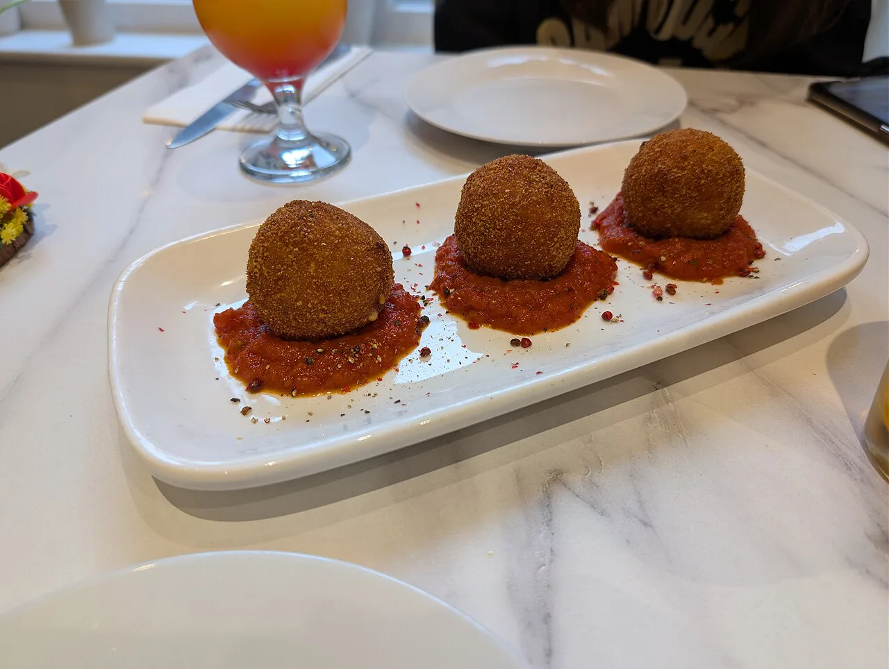 Arancini in tomato sauce on a plate.